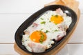 Scrambled eggs with bacon and fresh herbs fried in a pan. Served with bread toast Royalty Free Stock Photo