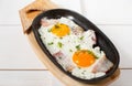 Scrambled eggs with bacon and fresh herbs fried in a pan. Served with bread toast Royalty Free Stock Photo