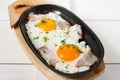 Scrambled eggs with bacon and fresh herbs fried in a pan. Served with bread toast Royalty Free Stock Photo