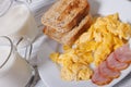 Scrambled eggs with bacon, toast and milk