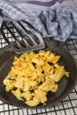 Scrambled eggs in a cast iron pan and a spatula