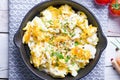 Scrambled eggs with chives in a cast iron pan, toasts with salmon and chives, and tomatoes. Healthy breakfasts on an old wooden wh Royalty Free Stock Photo