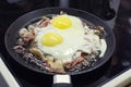 Scrambled eggs cooking in a frying pan, cooking on a ceramic stove, scrambled eggs with bacon Royalty Free Stock Photo