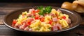 Scrambled eggs and ham with veggies in a bowl on a wooden table Royalty Free Stock Photo