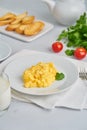 Scrambled eggs, omelet, vertical. Breakfast with pan-fried eggs, glass of milk, tomatoes on white background