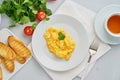 Scrambled eggs, Omelette. Breakfast with pan-fried eggs, cup of tea, tomatoes on white background. Top view Royalty Free Stock Photo