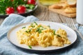 Scrambled eggs, omelette, close up. Breakfast with pan-fried eggs, cup of tea, tomatoes on old wooden table