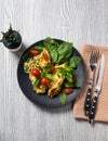 Scrambled eggs omelette portion for breakfast decorated with basil leaves and cherry tomatoes on a black porcelain plate. Knife Royalty Free Stock Photo