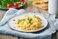 Scrambled eggs, omelette, side view. Breakfast with pan-fried eggs, cup of tea, tomatoes on old rustic wooden table Royalty Free Stock Photo