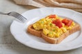 Scrambled eggs with tomato on toasted whole wheat bread Royalty Free Stock Photo