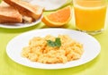 Scrambled eggs on white plate, toast and orange juice Royalty Free Stock Photo