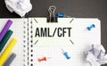 A scrap of blue paper with clips on a gray background with the text - aml cft