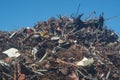 Scrap heap of rusty steel, aluminium under blue sky prepared to be recycled