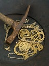 Scrap jewelry in gold pan with pick axe Royalty Free Stock Photo