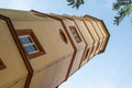 Scrap tower in the city of Schweinfurt with dynamic perspective, photographed in sunshine and blue skies framed by branches and