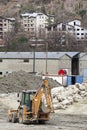 Scraper bulldozer. Construction site. Houses.