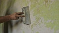 scraping off a layer of paint from a wall with a spatula Royalty Free Stock Photo