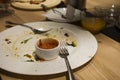 Scraps on the table. Empty plate with leftover food