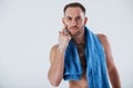 Scratch on face. Man with blue towel stands against white background in the studio Royalty Free Stock Photo