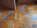 Scratched parquet flooring in the room. Scratches, chips and dents on the floor. Parquet in need of repair. Cabinet doors are Royalty Free Stock Photo