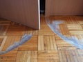 Scratched parquet flooring in the room. Scratches, chips and dents on the floor. Parquet in need of repair. Cabinet doors are Royalty Free Stock Photo