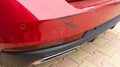 Scratched red car rear bumper in minor accident street vehicle damaged in collision Royalty Free Stock Photo