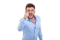 Screaming angry young bearded emotional man standing over white wall background isolated.