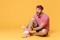 Screaming bearded fitness sporty guy sportsman in headband t-shirt in home gym isolated on yellow background. Workout