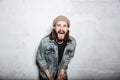 Screaming bearded hipster man posing over wall background. Royalty Free Stock Photo
