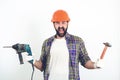 Screaming builder in helmet. Bearded man holding drill and hammer. Butal builder man. Construction worker in hard hat Royalty Free Stock Photo