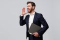 Screaming businessman holding laptop and looks at side over grey studio background Royalty Free Stock Photo