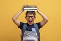 Screaming cute boy schooler with book on his head