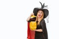 Screaming funny young woman in witch hat with jack-o-lantern in her hands. Halloween party. White background, space for text Royalty Free Stock Photo