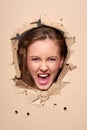 Screaming girl peeping through hole in paper Royalty Free Stock Photo