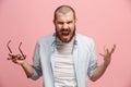 The young emotional angry man screaming on pink studio background Royalty Free Stock Photo