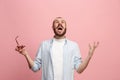 The young emotional angry man screaming on pink studio background Royalty Free Stock Photo