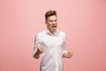 The young emotional angry man screaming on pink studio background Royalty Free Stock Photo