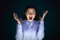 Close up portrait of young crazy scared and shocked woman isolated on dark background Royalty Free Stock Photo