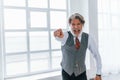 Screaming senior man in jacket and tie indoors in room against window Royalty Free Stock Photo