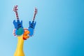 Screaming toy chicken in glasses on a blue background. Toy yellow shrilling chicken on blue background. Copyspace Royalty Free Stock Photo