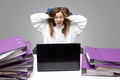 Screaming woman at desk with laptop and folders. Female entrepreneur suffers from nervous breakdown caused by fatigue, too much