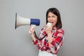 Screaming young asian woman holding loudspeaker. Royalty Free Stock Photo