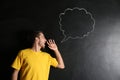 Screaming young man and blank speech bubble drawn on dark background Royalty Free Stock Photo