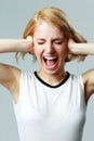 Screaming young woman with closed ears