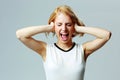 Screaming young woman with closed ears