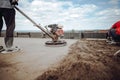 Screed details. Construction workers leveling sand and cement screed over roof terrace concrete