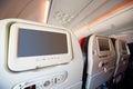 Screens for passengers in back of soft seats in airplane. Royalty Free Stock Photo