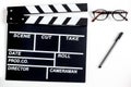 Screenwriter desktop with movie clapper board white background top view