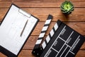 Screenwriter desktop with movie clapper board wooden background top view Royalty Free Stock Photo