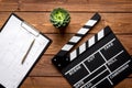 Screenwriter desktop with movie clapper board wooden background top view Royalty Free Stock Photo